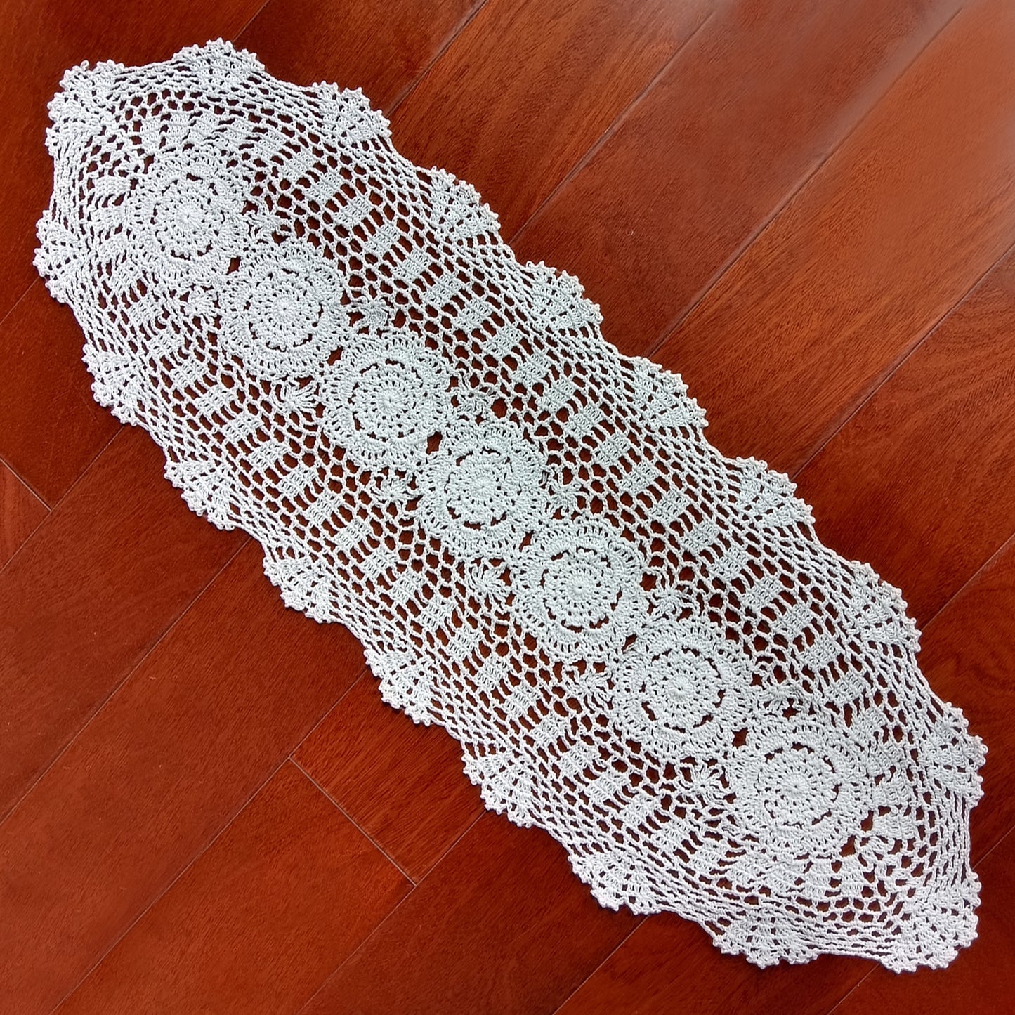 12x35 White crocheted table runner on a wooden floor