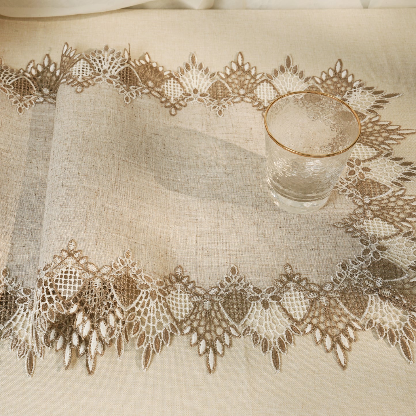 Glass of water on a lace-trimmed tablecloth