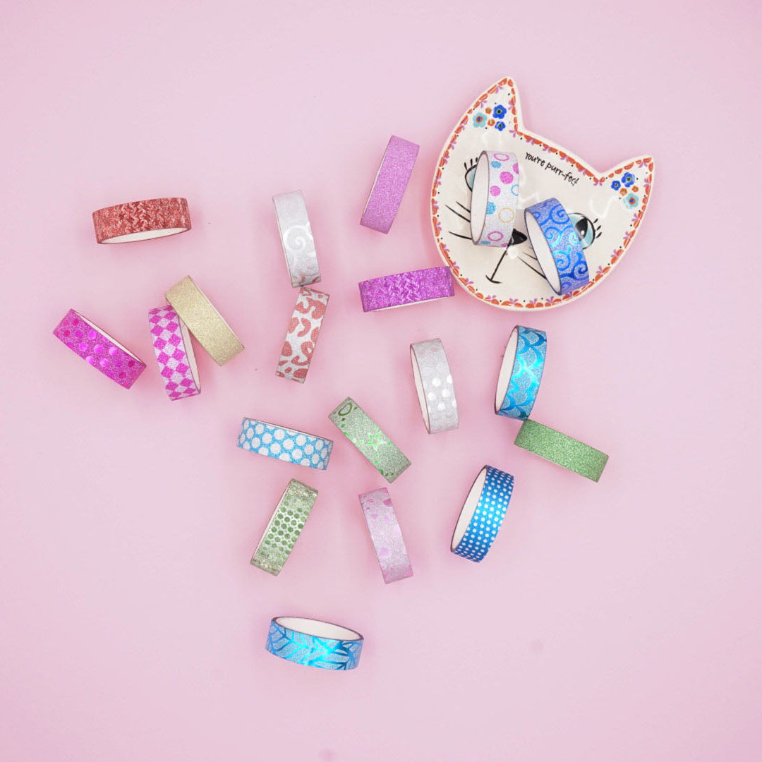 Assorted washi tape rolls on a pink background