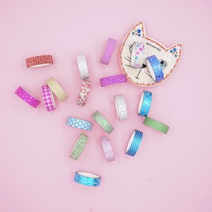 Assorted washi tape rolls on a pink background