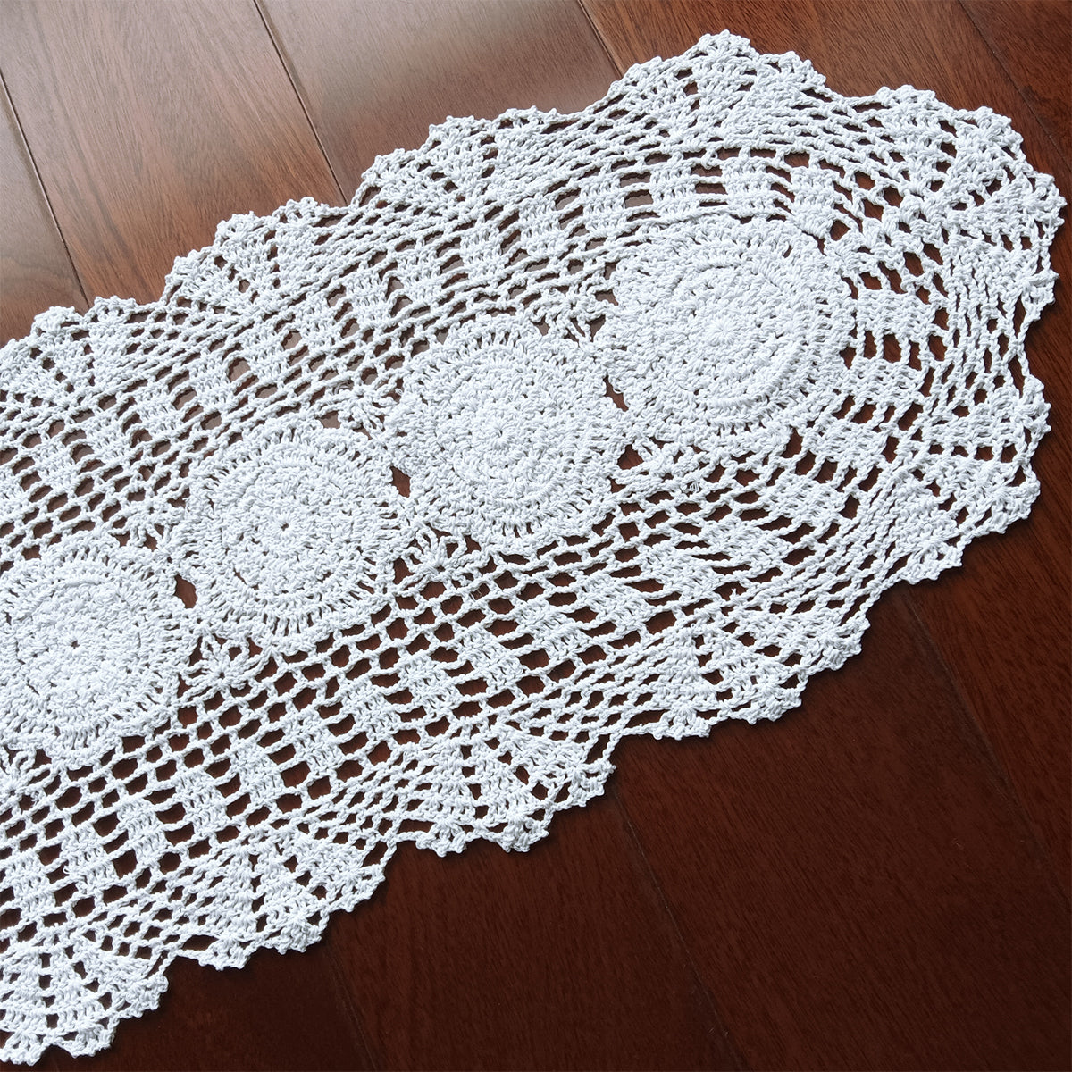 White handmade crocheted doily on a wooden surface