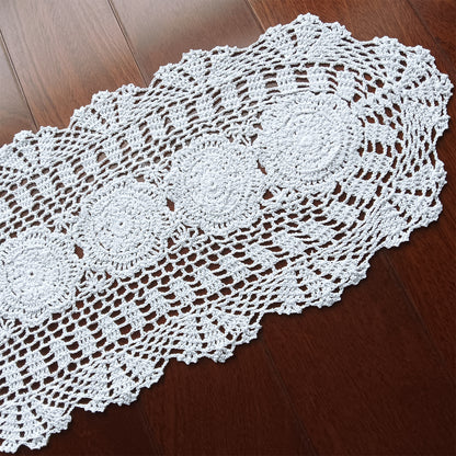 White handmade crocheted doily on a wooden surface